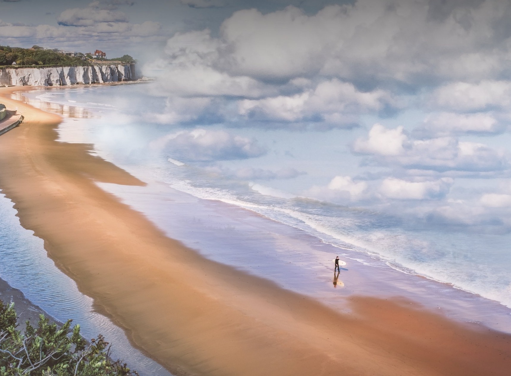 Man met surfplank onder zijn arm op het strand